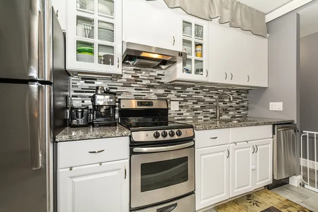 a kitchen with stainless steel appliances granite countertop a stove and a sink