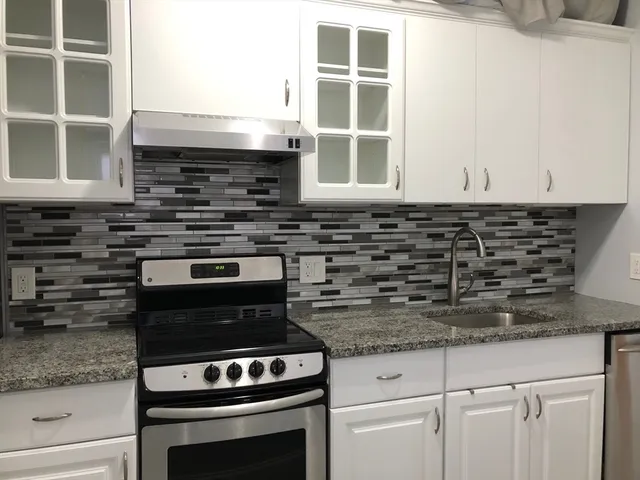 a kitchen with granite countertop a stove and a sink
