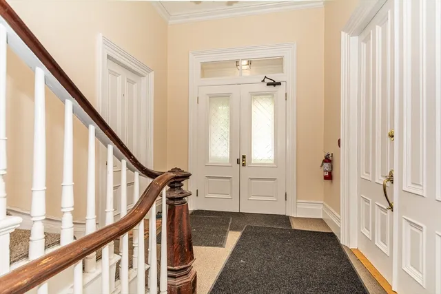 a view of a hallway with wooden floor and staircase