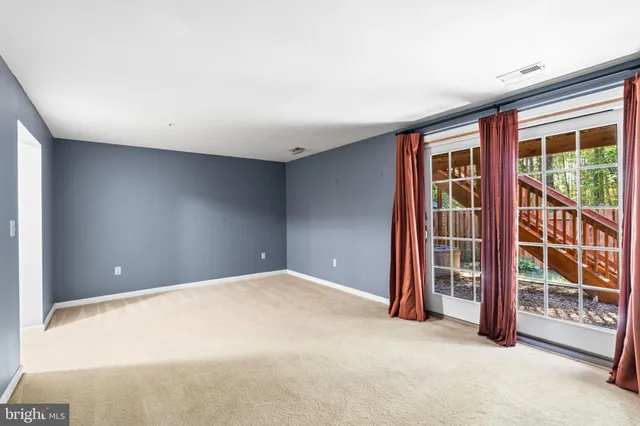an empty room with floor to ceiling window and an outdoor view