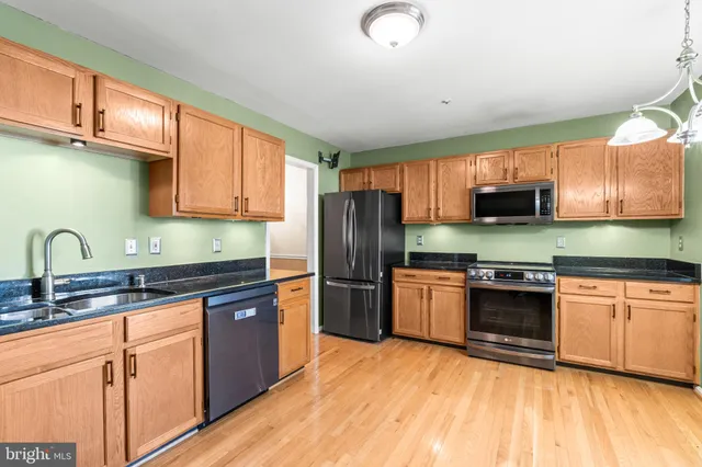 a kitchen with granite countertop stainless steel appliances and wooden cabinets