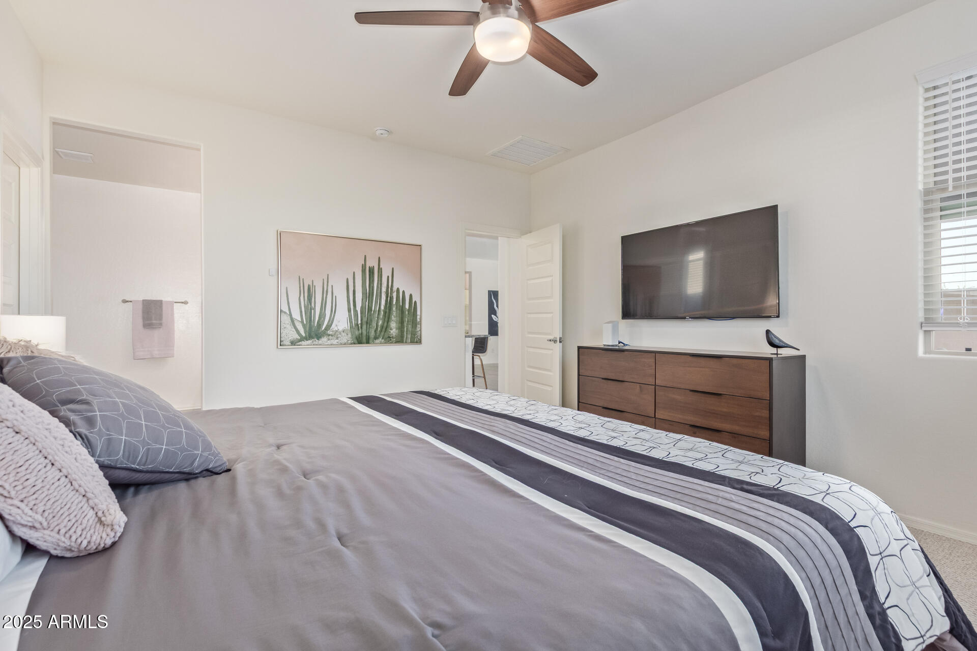 17796 West Sandy Road Goodyear, AZ 85338 - Photo 21 of 68 a bedroom with a large bed and a flat screen tv