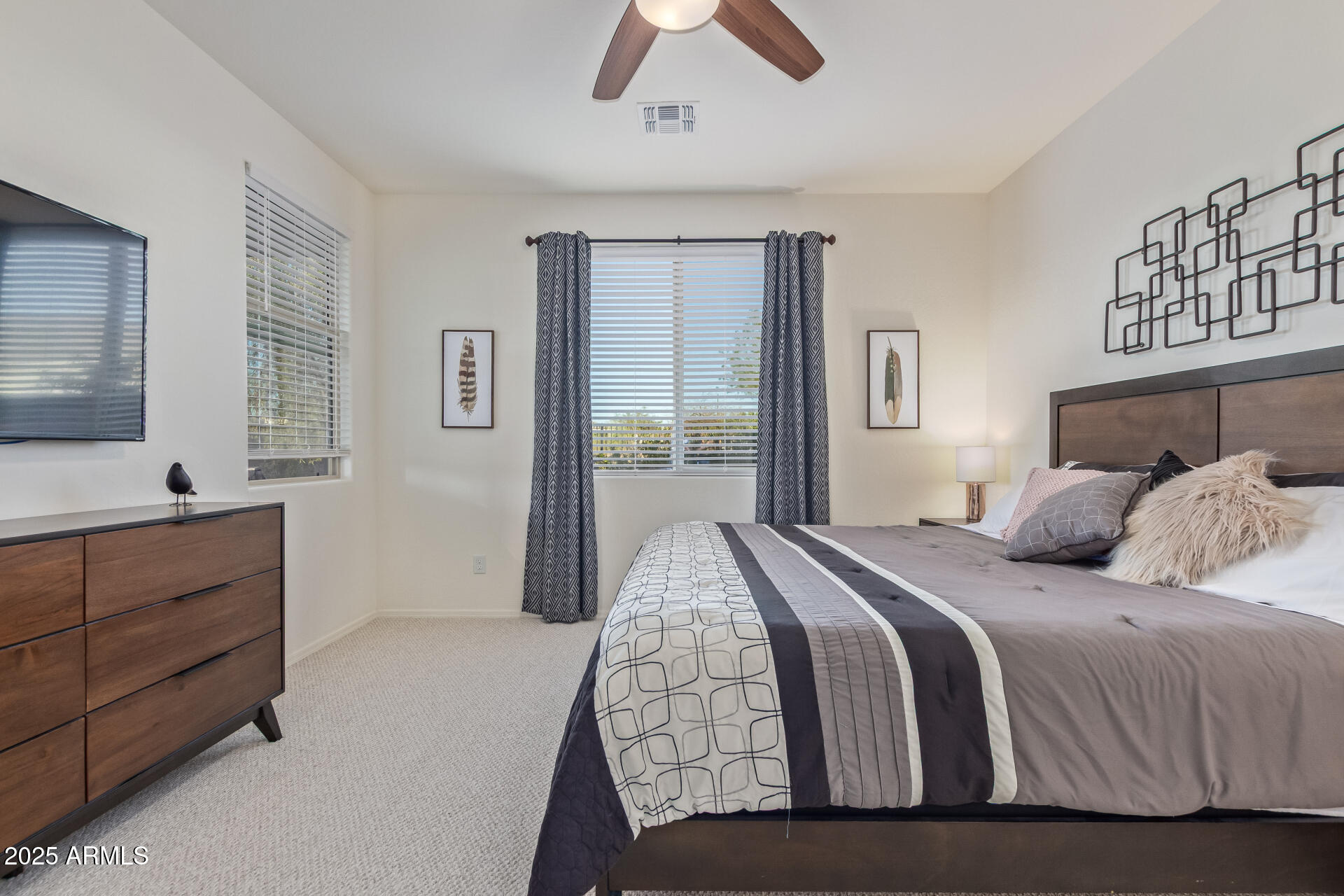17796 West Sandy Road Goodyear, AZ 85338 - Photo 23 of 68 a bedroom with a large bed and a flat tv screen on dresser
