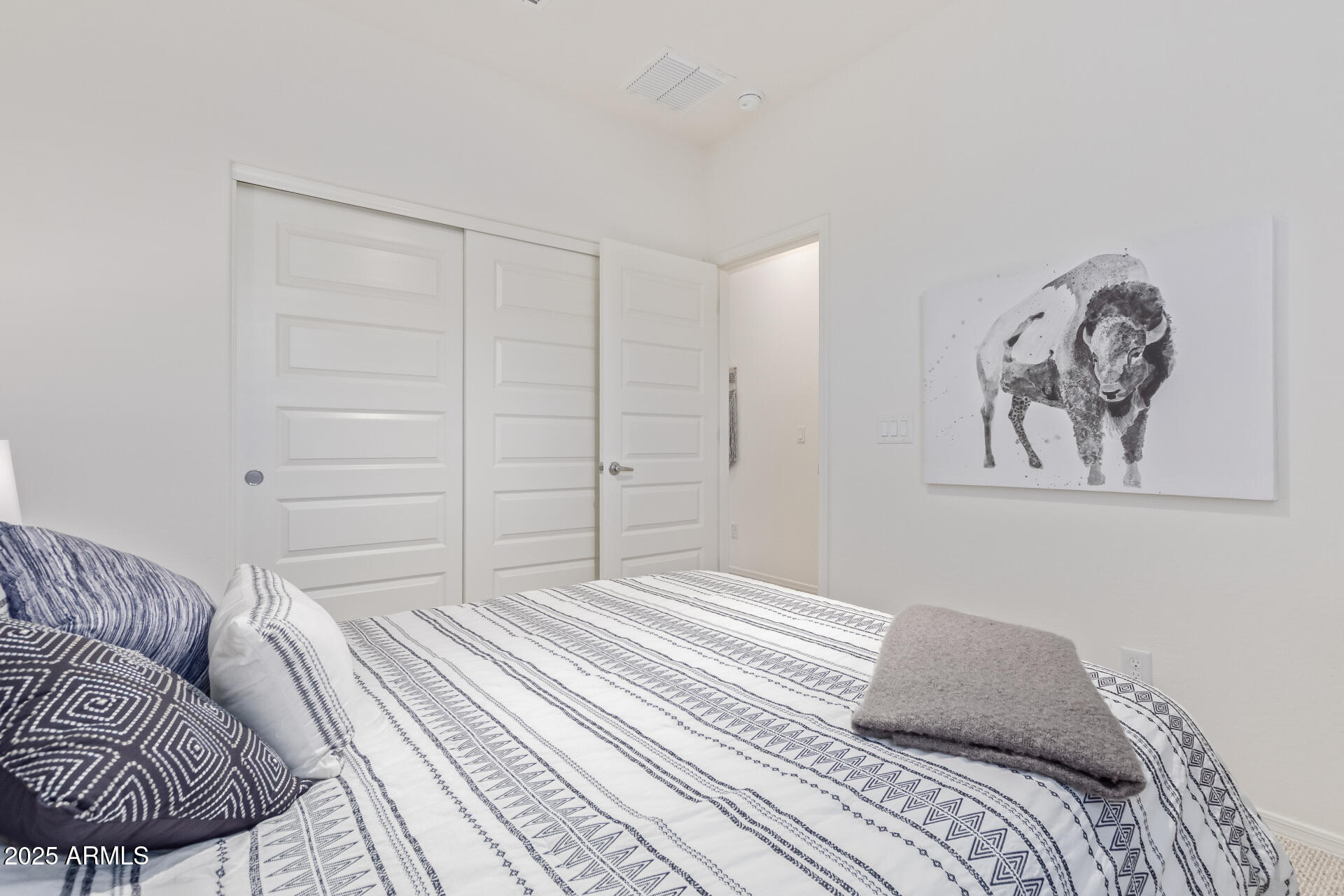 17796 West Sandy Road Goodyear, AZ 85338 - Photo 31 of 68 a bedroom with a bed and a painting on the wall