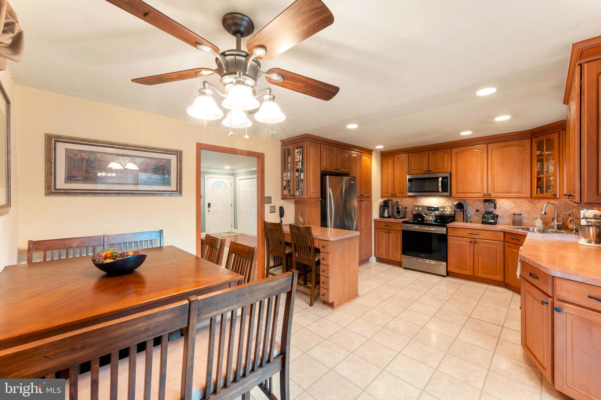 992 Jamison Street Warminster, PA 18974 - Photo 14 of 37 a kitchen with stainless steel appliances kitchen island granite countertop a table chairs in it and a microwave