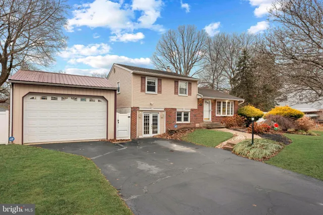 a front view of a house with a garden and trees
