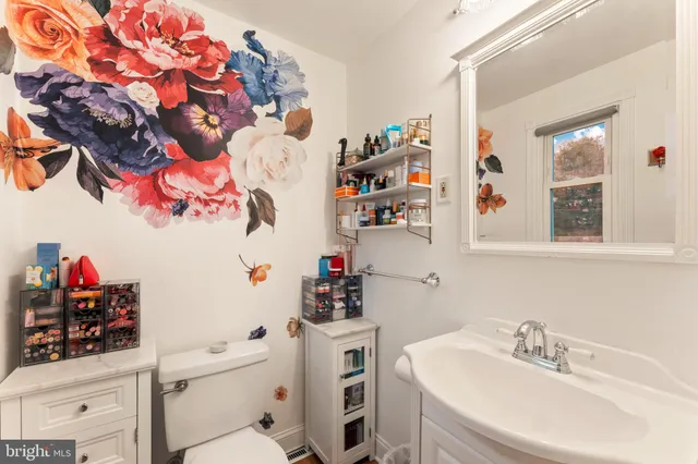 a bathroom with a sink vanity mirror and toilet