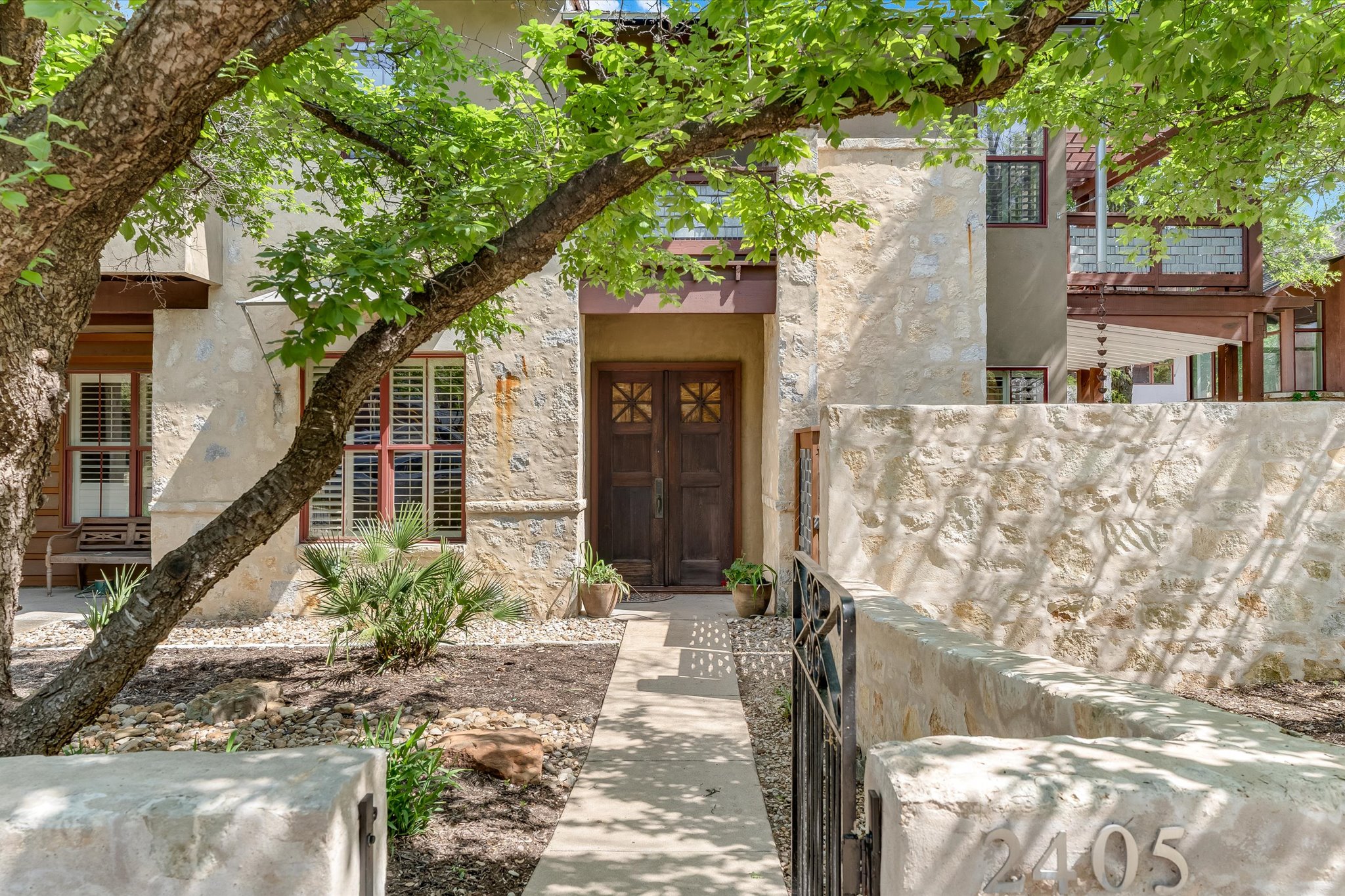 Main Entry with stone and stucco siding and antique doors