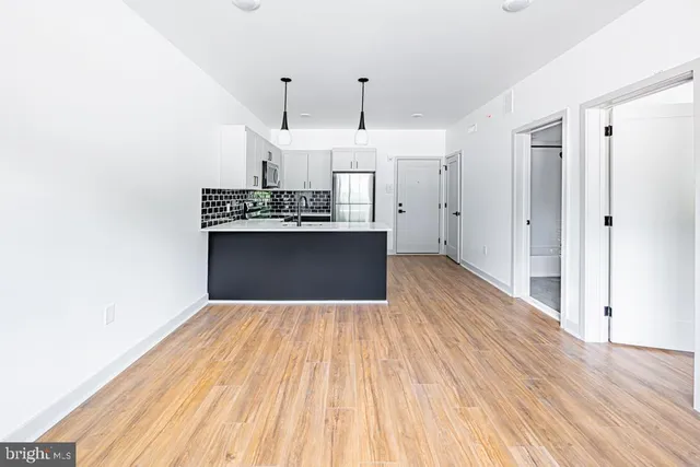 a view of kitchen with stainless steel appliances refrigerator stove microwave and cabinets
