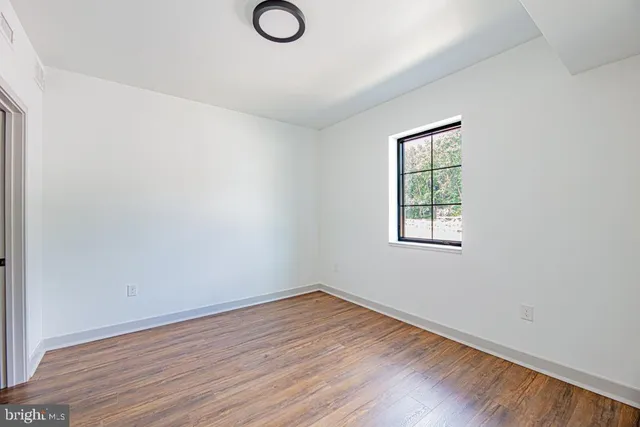 a view of a room with wooden floor and white doors