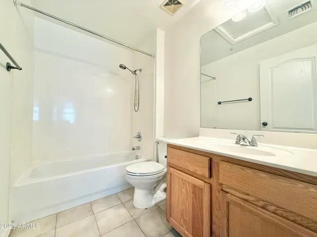 a bathroom with a granite countertop sink toilet mirror and bathtub