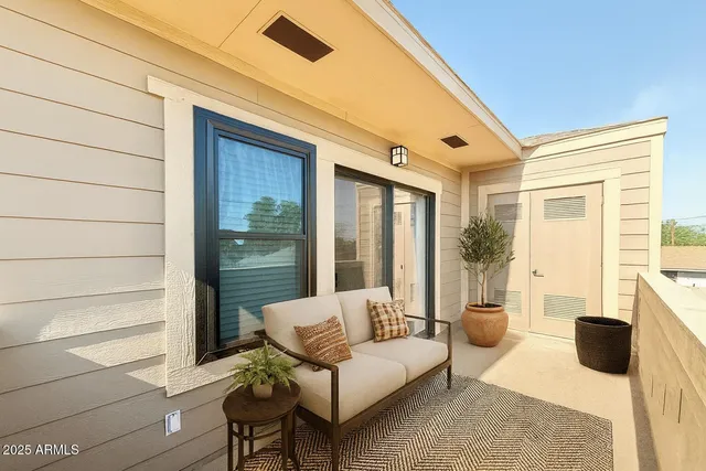 a balcony with furniture and a potted plant