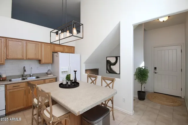 a kitchen with a table a sink cabinets and appliances