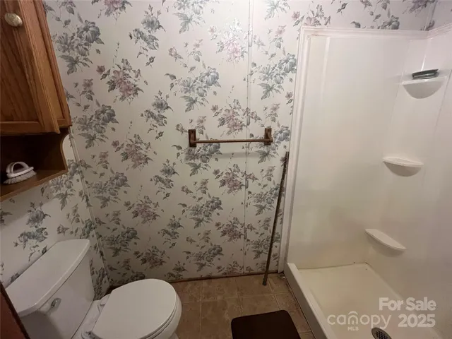 a bathroom with a toilet and a shower