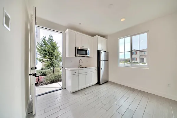 a room with a balcony a bed a couch and large window