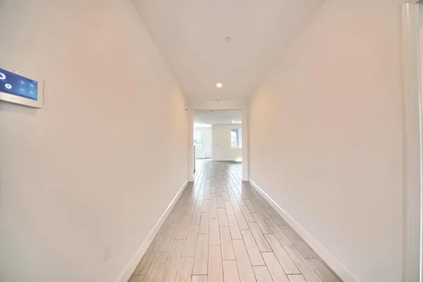 a view of a hallway with wooden floor