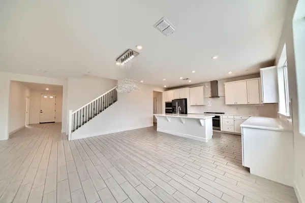 a view of kitchen with cabinets stainless steel appliances and wooden floor