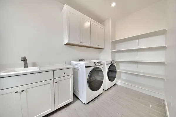 a utility room with sink dryer and washer
