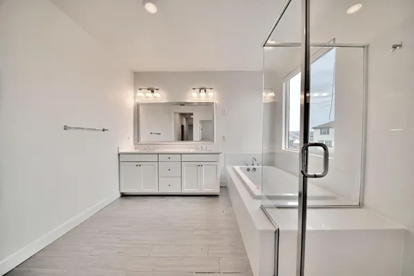 a bathroom with a bathtub a shower a sink and a window