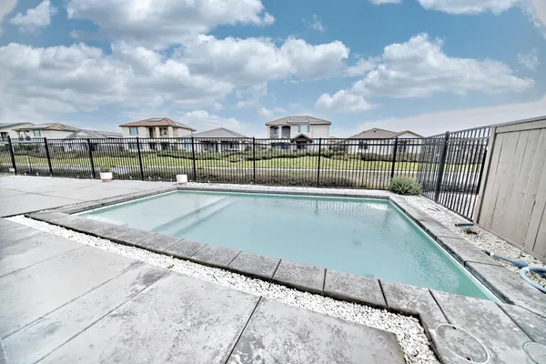 a swimming pool with barbeque oven in front of it