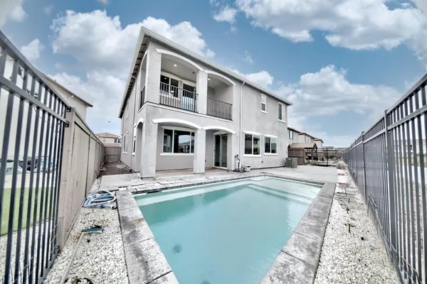 a view of house with large windows and a small yard