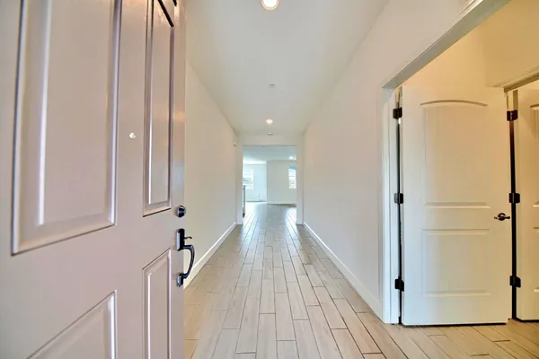 a view of a hallway with wooden floor and staircase