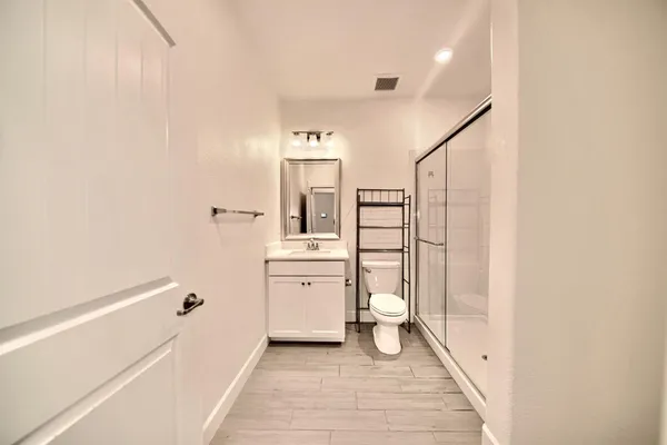 a spacious bathroom with a granite countertop sink a toilet and shower