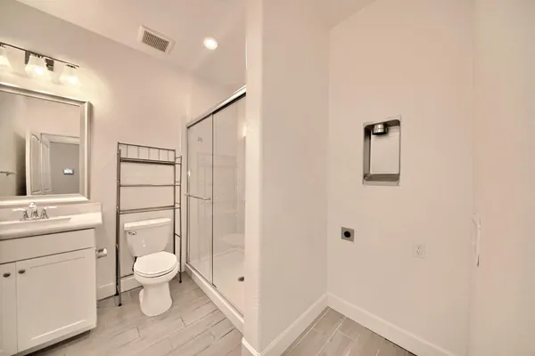 a bathroom with a granite countertop sink a toilet and shower