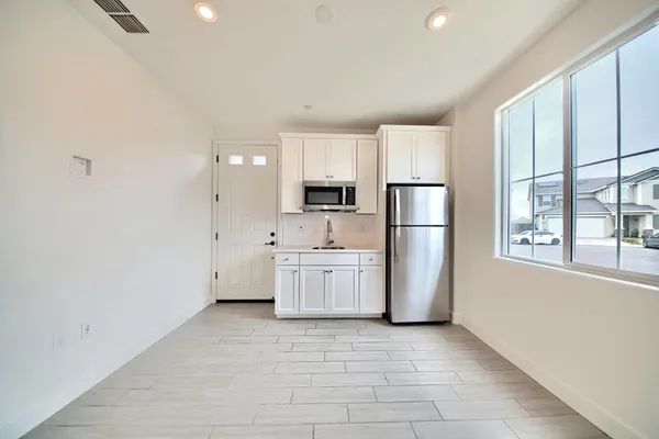 a kitchen with a refrigerator a stove top oven and cabinets