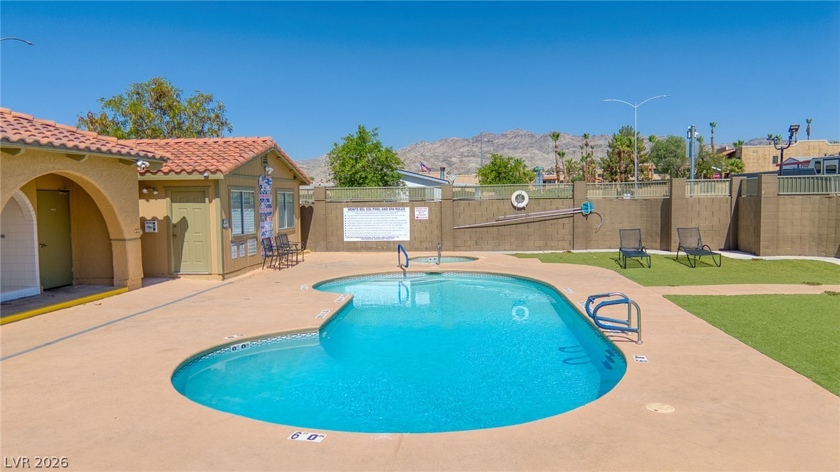 3189 Del Monte Street Laughlin, NV 89029 - Photo 27 of 32 A sparkling pool and inviting spa await, with serene mountain views providing a picturesque backdrop.