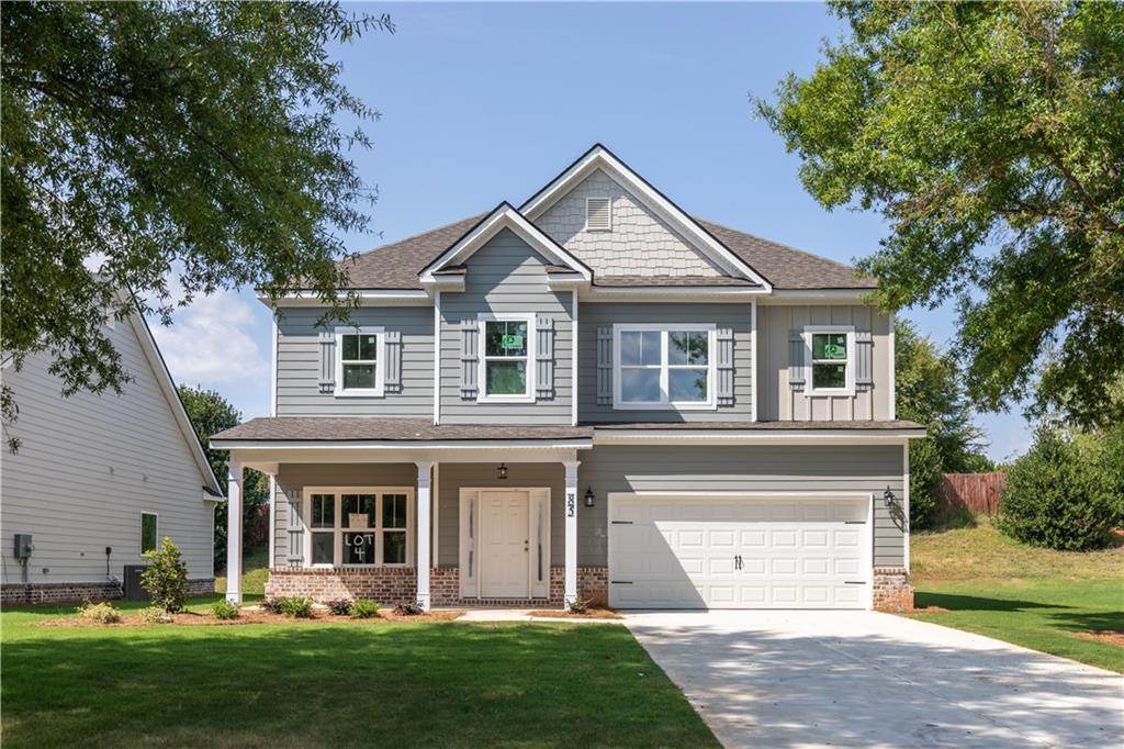 a view of a yard in front of a house with a large tree