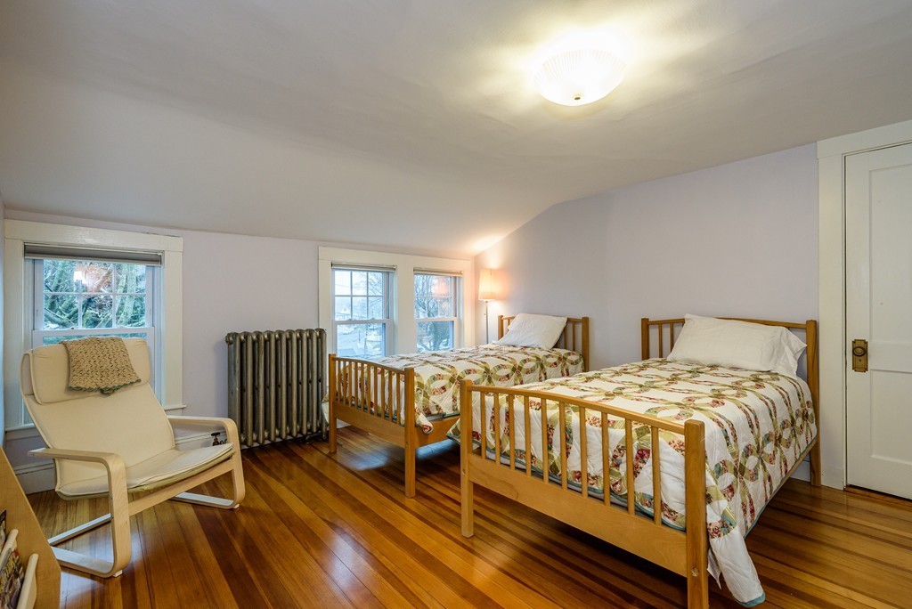 176 Manthorne Road, Unit 2 Boston, MA 02132 - Photo 11 of 16 a bedroom with a bed and wooden floor