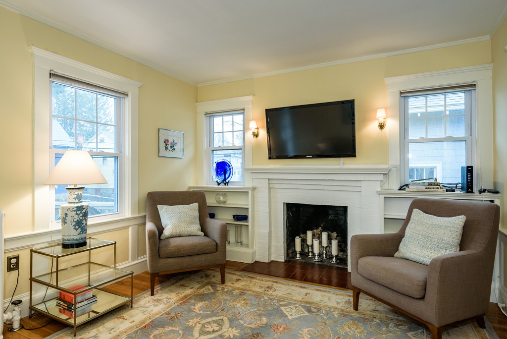 176 Manthorne Road, Unit 2 Boston, MA 02132 - Photo 3 of 16 a living room with furniture a flat screen tv and a fireplace