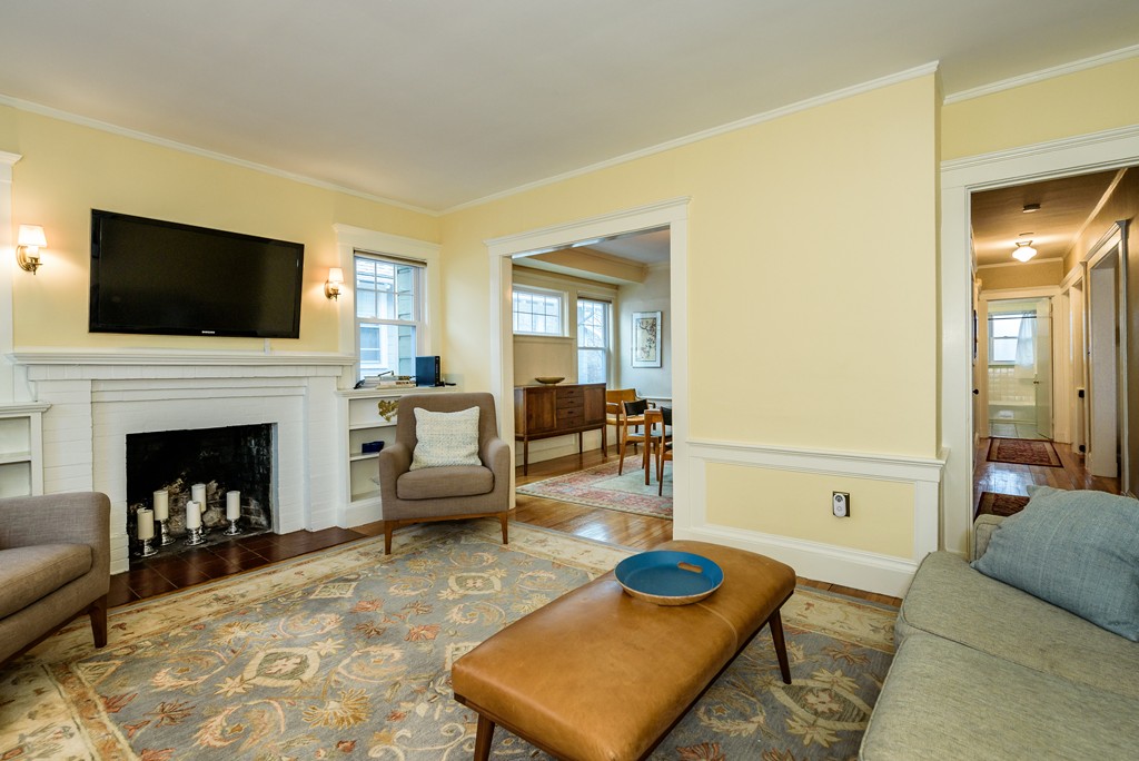 176 Manthorne Road, Unit 2 Boston, MA 02132 - Photo 4 of 16 a living room with furniture a flat screen tv and a fireplace