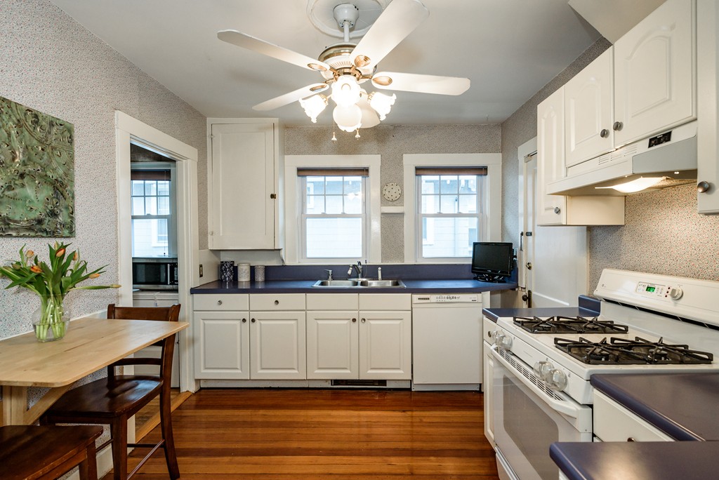 176 Manthorne Road, Unit 2 Boston, MA 02132 - Photo 5 of 16 a kitchen with a stove a sink and a refrigerator