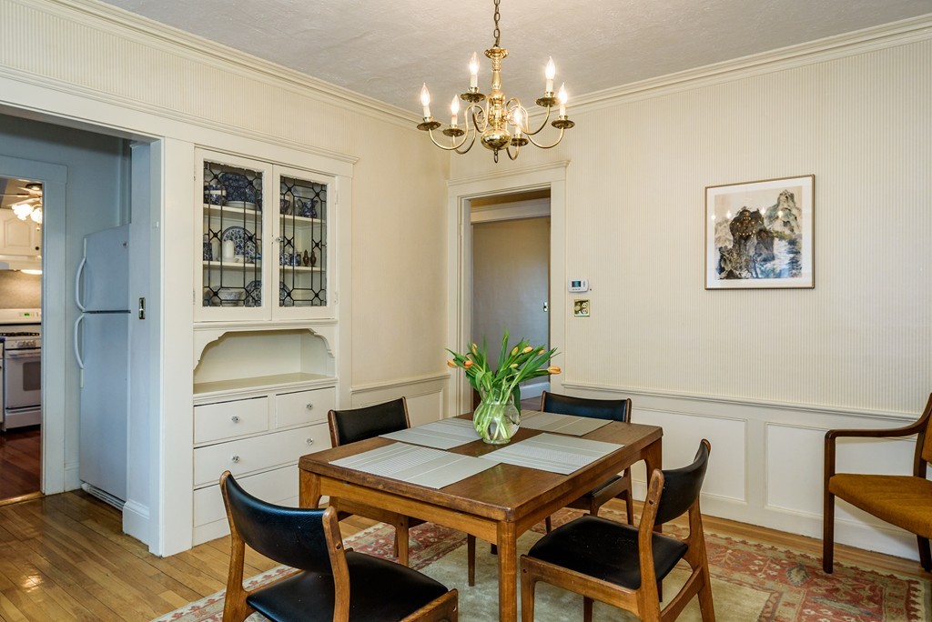 176 Manthorne Road, Unit 2 Boston, MA 02132 - Photo 7 of 16 a dining room with furniture a chandelier and wooden floor