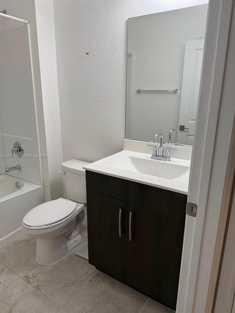 13280 Southwest 272nd Street, Unit 2 Homestead, FL 33032 - Photo 4 of 8 a bathroom with a sink vanity mirror and toilet