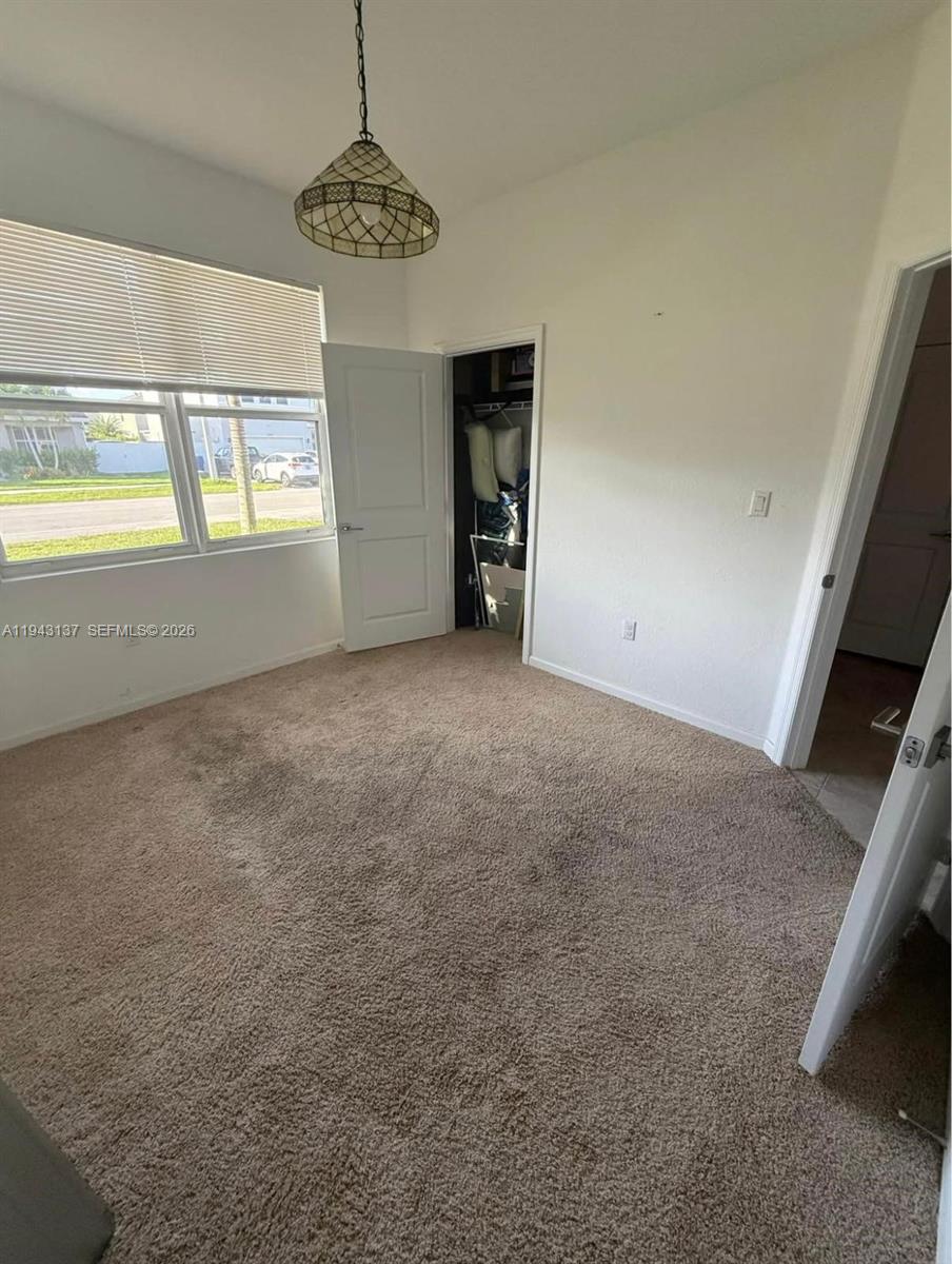 13280 Southwest 272nd Street, Unit 2 Homestead, FL 33032 - Photo 5 of 8 a view of an empty room with a window