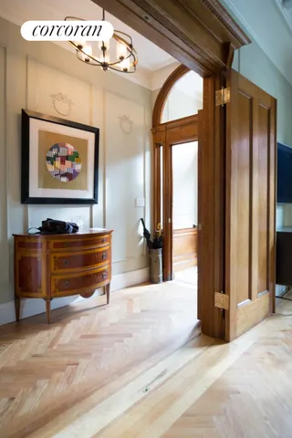 a view of a hallway with wooden floor and a potted plant