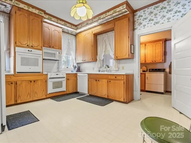 a kitchen with a refrigerator a stove and wooden cabinets