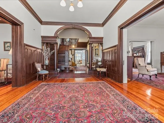 a living room with furniture a fireplace and a chandelier