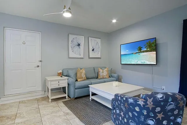 a living room with furniture a rug and a painting on the wall