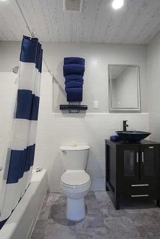 a bathroom with a toilet a sink and mirror
