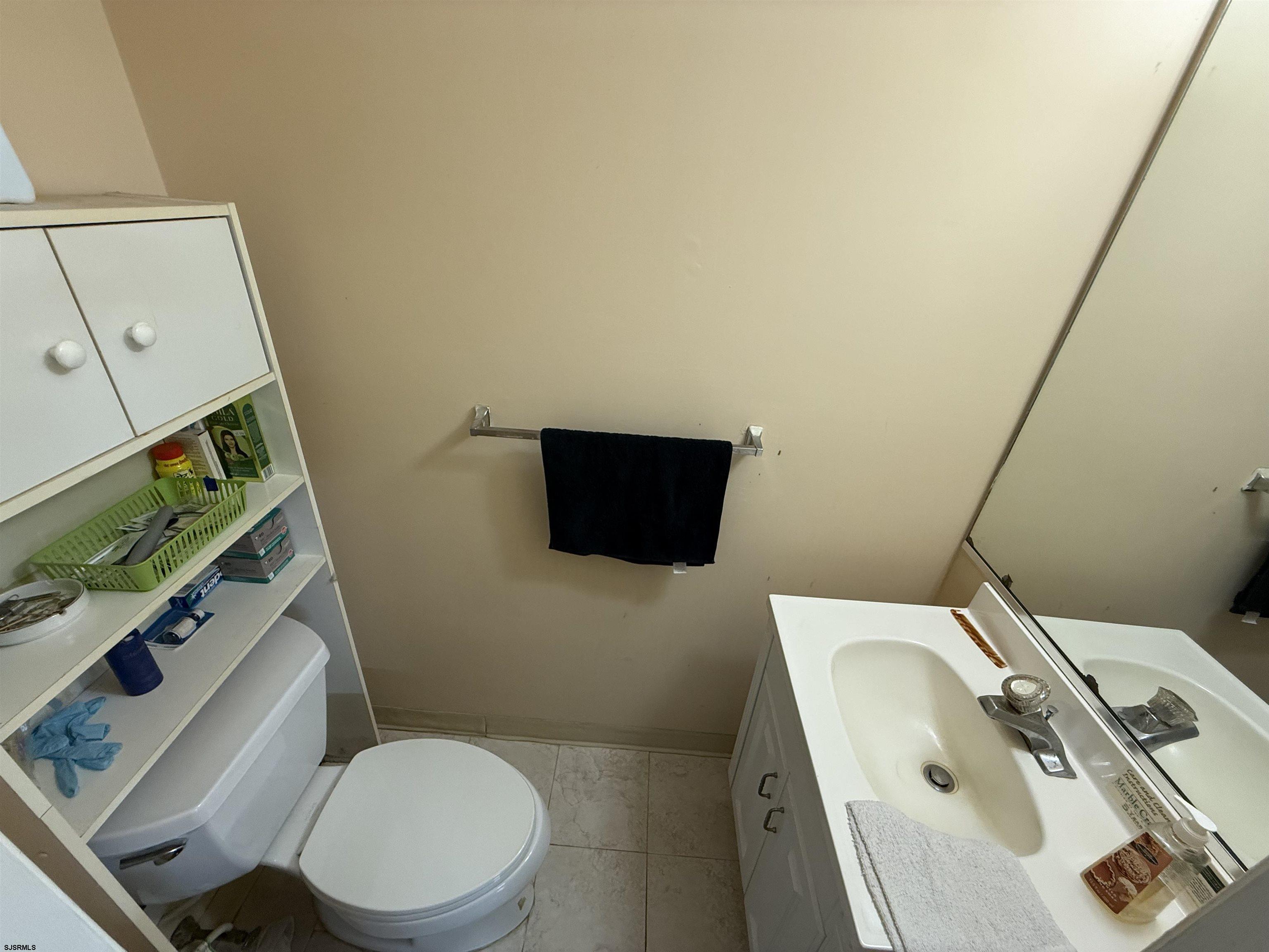 720 South New Road, Unit 5M Absecon, NJ 08201 - Photo 7 of 14 a white toilet sitting next to a sink and vanity
