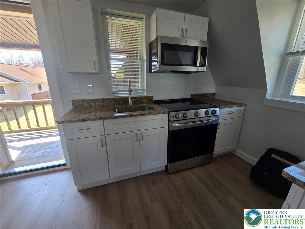 1731 West 8th Street Wind Gap, PA 18091 - Photo 6 of 13 a kitchen with granite countertop wooden cabinets and a stove