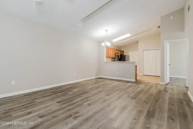 a view of empty room with wooden floor