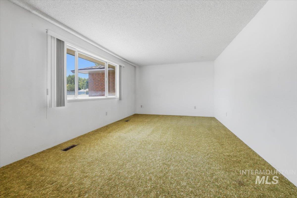 1311 North Middleton Road Nampa, ID 83651 - Photo 18 of 49 Bright room featuring a large horizontal window with vertical blinds, providing abundant natural light
