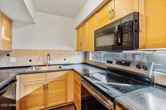 a kitchen with wooden cabinets stove and sink
