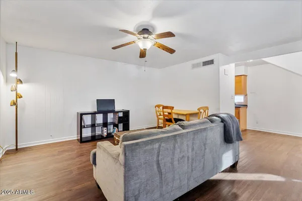 a living room with furniture and a wooden floor