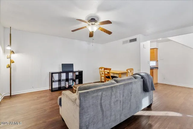 a living room with furniture and a wooden floor